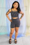 Black straight size female model with locs wearing black and white striped crop top and high waist shorts ethically handmade