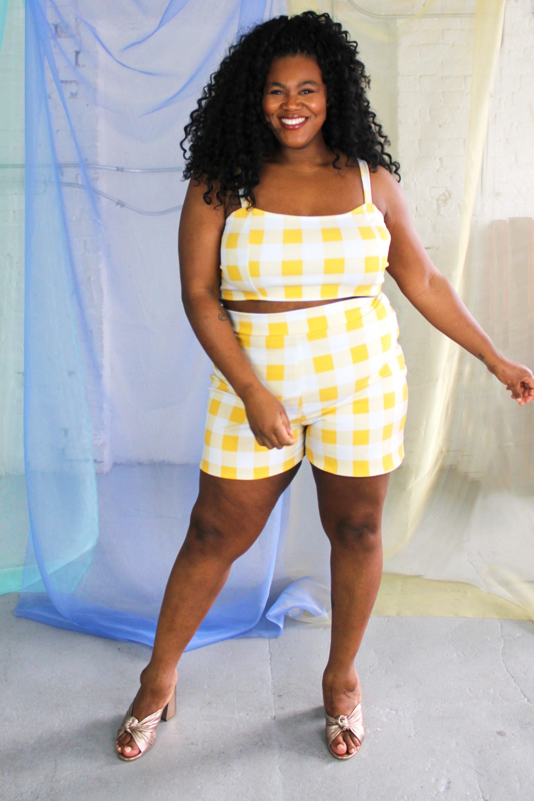 Black plus size female model with curls wearing yellow and white check crop top and high waist shorts ethically handmade