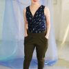 White petite straight size non binary model with brunette pixie haircut wearing navy cactus print tank and olive green pants