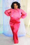 Plus size black model with curly hair wearing pink organza blouse with neck tie + bell sleeves with red satin pants handmade