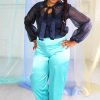 Straight size black model with braided hair wearing navy organza blouse with neck tie + bell sleeves with seafoam satin pants