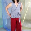Straight size tall white brunette trans model wearing red maroon capri pants with pockets and black + white gingham wrap top