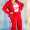Plus size tall black model with short curly hair wearing red suit and pink satin camisole, ethically handmade in NYC