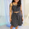 Black smiling straight size model with locs modeling black and white striped crop top and skirt - ethically handmade in NYC