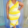Smiling black plus size model wearing yellow Nadine striped jersey dress with a v-neck and ruffle at bottom of fitted skirt.