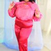 Plus size black model with curly hair wearing pink organza blouse and red satin wide leg pants, ethically handmade in NYC