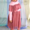 Hijabi plus size model wearing dusty rose pink mesh skirt smiling and happy, with matching long sleeve ruffle top