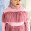 Hijabi plus size model wearing dusty rose pink mesh high neck long sleeved top with ruffle and matching skirt