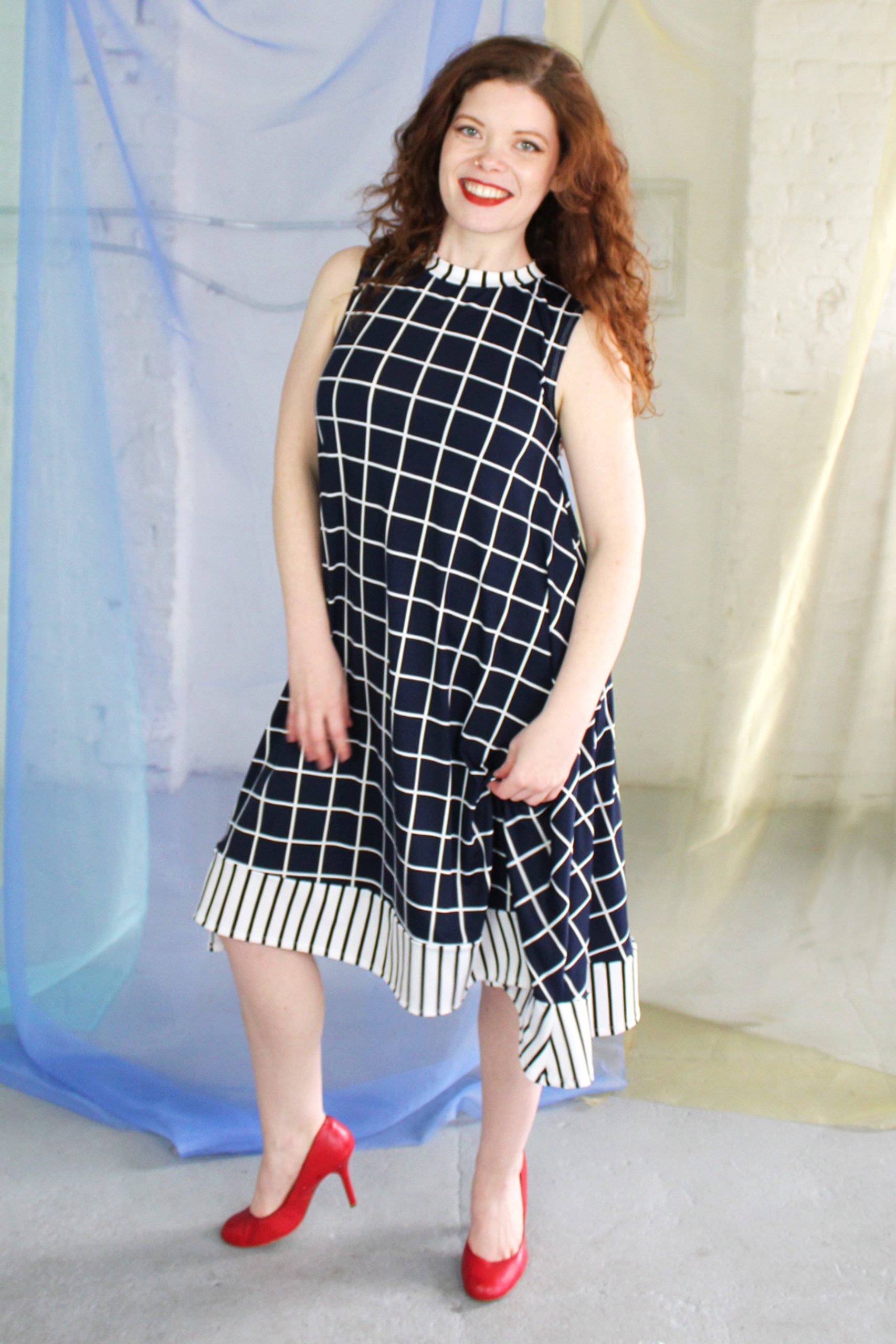 Straight size white redhead model wearing dark navy and white swing dress with striped trim, ethically handmade in NYC