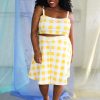 Black smiling plus size model modeling yellow and white check crop top, shorts, and over skirt - ethically handmade in NYC